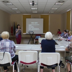 Grupa osób patrzą w kierunku prowadzącej spotkanie