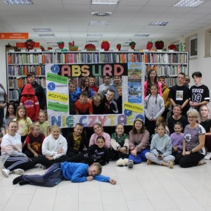 Uczestnicy i organizatorzy Nocy Bibliotek pozują przy fotobudce.