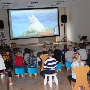 Dzieci oglądają wyświatlany film.