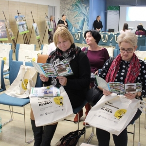 Bibliotekarki z zainteresowaniem oglądają ulotki informacyjne.