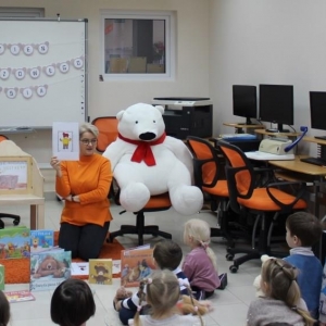 Pani bibliotekarka pokazuje dzieciom obrazek z misiem