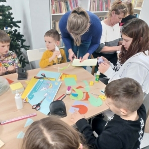 Rodzice i dzieci podczas pracy przy wykonywaniu choinkowych ozdób z papieru