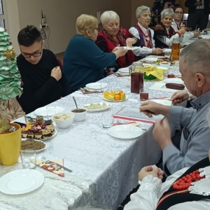 Uczestnicy koledowania dzielą się opłatkiem.