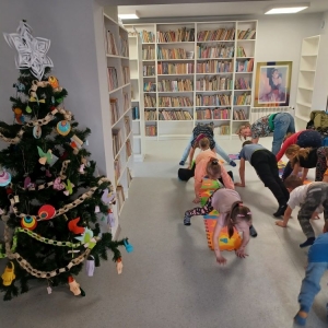 Dzieci naśladują sposób chodzenia bibliotekarki, maszerując na czterech