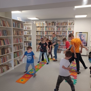 Dzieci naśladują sposób chodzenia bibliotekarki, maszerują w rozkroku