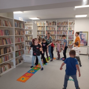 Dzieci naśladują sposób chodzenia bibliotekarki, maszerują w rozkroku