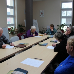 Grupa seniorów rozmawiają między sobą.