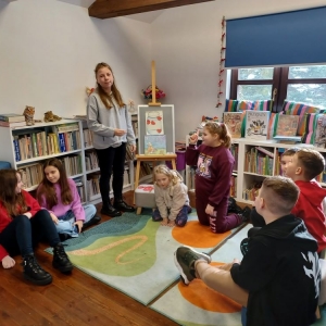 Uczestnicy ferii w bibliotece podczas rozmowy o Święcie Babci i Dziadka