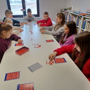 Uczestnicy ferii w bibliotece podczas gry w bingo