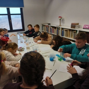 Uczestnicy ferii w bibliotece malują farbami portret Pipi Pończoszanki