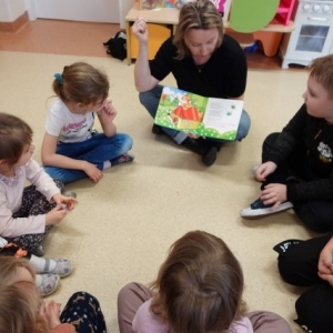 Spotkanie Klubu Małego Czytelnika - bibliotekarka czyta dzieciom książkę