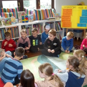 Dzieci z bibliotekarką podczas spotkania Klubu Małego Czytelnika