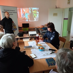 Seniorki rozmawiają z policjantką.