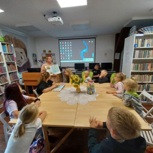 Bibliotekarka pokazuje dzieciom w książce portret Vincenta van Gogha