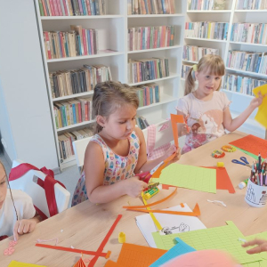 Trzy dziewczynki podczas zajęć w bibliotece