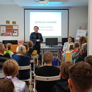 Bibliotekarka wita uczestników spotkania i przedstawia gościa