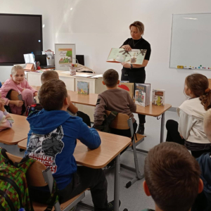 Bibliotekarka czyta dzieciom książkę pt. "Ernest"