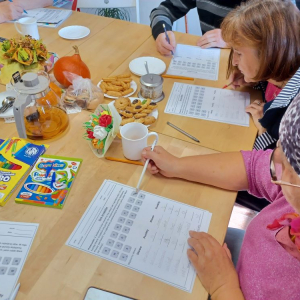 Troje seniorów rozwiązuje zadania słowne