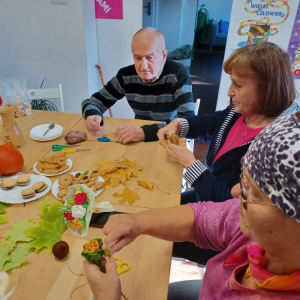 Seniorzy podczas warsztatu robienia róż z liści