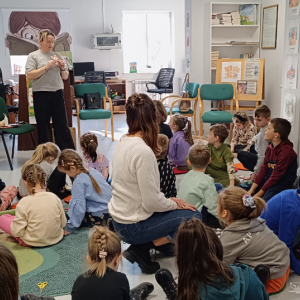 Bibliotekarka Ania przekazuje dzieciom jak zrobić misia z papieru