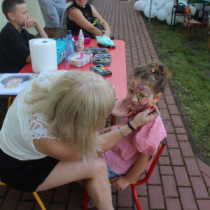 Kobieta maluje twarz dziecka