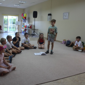 Chłopiec przed grupą prezentuje kalambury