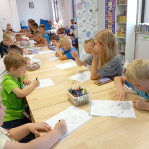 Grupa dzieci koloruje obrazki