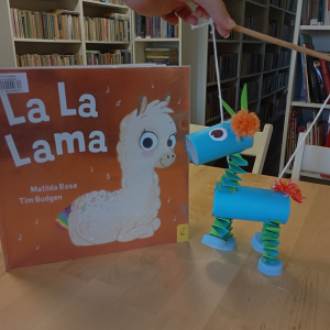 Książka "La, la Lama", obok papierowa figurka lamy