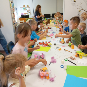 Duża grupa dzieci wykonuje lamy z materiałów z recyklingu