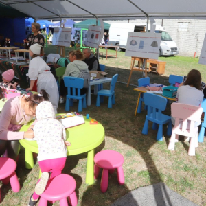 Uczestnicy pikniku odwiedzający stoisko biblioteczne