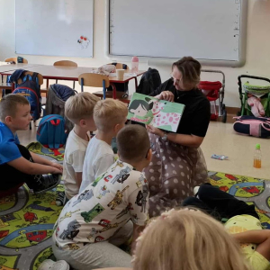 Bibliotekarka pokazuje dzieciom ilustracje z książki