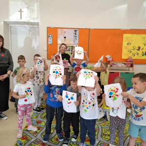 Zdjęcie grupowe dzieci z opiekunką i bibliotekarką z okazji Dnia Kropki