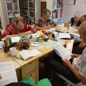 Grupa seniorów na spotkaniu Siłowni Pamięci w bibliotece