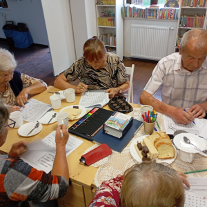 Grupa seniorów rozwiązuje zagadki logiczne