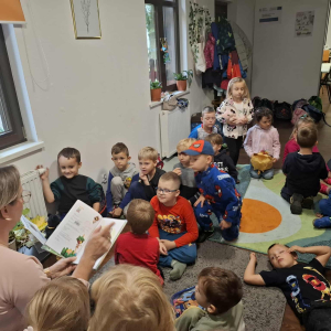 Spotkanie KLubu małego Czytelnika w bibliotece, bibliotekarka czyta dzieciom opowiadanie