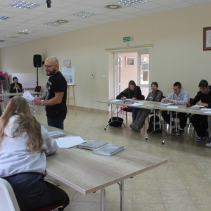 Prowadzący wwarsztaty rozdaje materiały