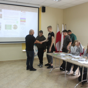 Prowadzący wręcza uponimnki uczestnikom