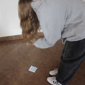 Osoba fotografuje kod QR leżący na podłodze