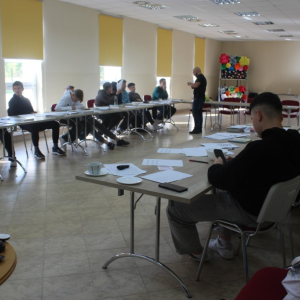 Młodzież siedzi przy stołach