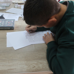 Chłopiec notuje przy stole