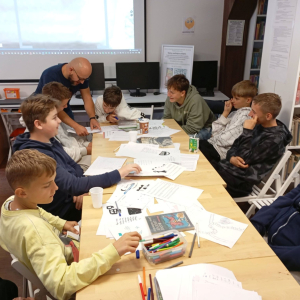 Karol Baranowski udziela wskazówek młodzieży na temat gry planszowej