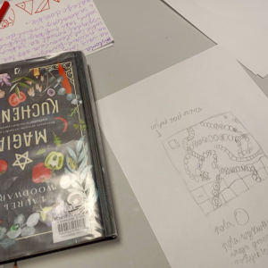 Na stole książka, obok szkic gry planszowej