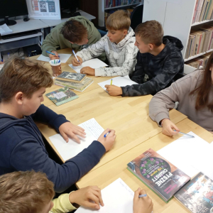 Grupa młodzieży pracująca nad projektem gry planszowej