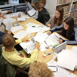 Grupa młodzieży pracuje nad projektem gry