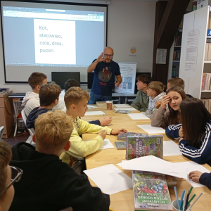 Prowadzący omawia grupie młodzieży temat warsztatów.