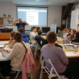 Prowadzący omawia grupie młodzieży temat warsztatów