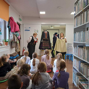 Dwie panie z KGW pokazują dzieciom dawny strój ludowy.