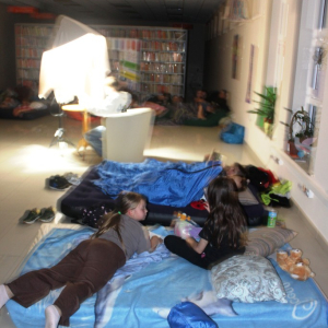 Dzieci leżą na materacach 