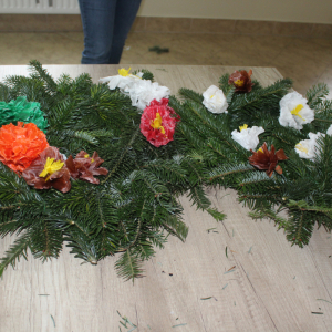 Dwie korony nagrobne z kolorowymi kwiatami z bibuły