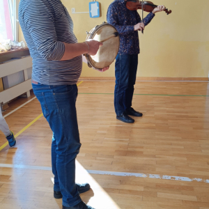 prowadzący graja na instrumentach - bębenek i skrzypce